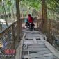 Pengendara motor saat melawati jembatan gantung yang ada di Desa Daleman, Kecamatan Kedungdung, Sampang dengan kondisi membahayakan.