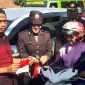 Ketua Persatuan Wartawan Sampang Ahmad Juma'adi (kiri) bersama Polwan Polres Sampang saat memasang bendera mini ke kendaraan yang dikendarai salah satu pengendara motor.