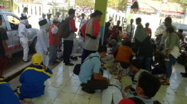 Petugas mengevakuasi peserta lomba gerak jalan yang jatuh pingsang.