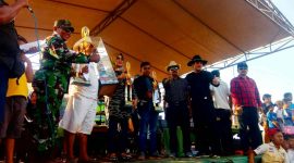 Agus, pemilik kuda Zorro saat menerima piala bergilir dari salah satu anggota TNI di lapangan balap kuda keleyan Bangkalan.