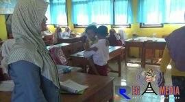 Muhammad Zainul Fata tengah menggendong adiknya kedalam kelas.