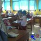 Muhammad Zainul Fata tengah menggendong adiknya kedalam kelas.