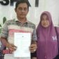 Hafiluddin bersama istrinya saat menunjukkan tanda terima laporan dari Polda Jatim.