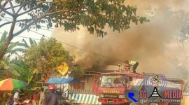 Petugas pemadam kebaran mencoba memadam api yang tengah menjalar bagian pos polisi.