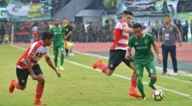 Pemain lini belakang Madura United Fabiano Baltrame mencoba menghalangi laju pemain Persebaya Surabaya.