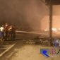 Tim pemadam kebakaran saat memadamkan api yang melalap habis gudang kayu dan rumah makan di Jl . Raya Sejati, Sampang.
