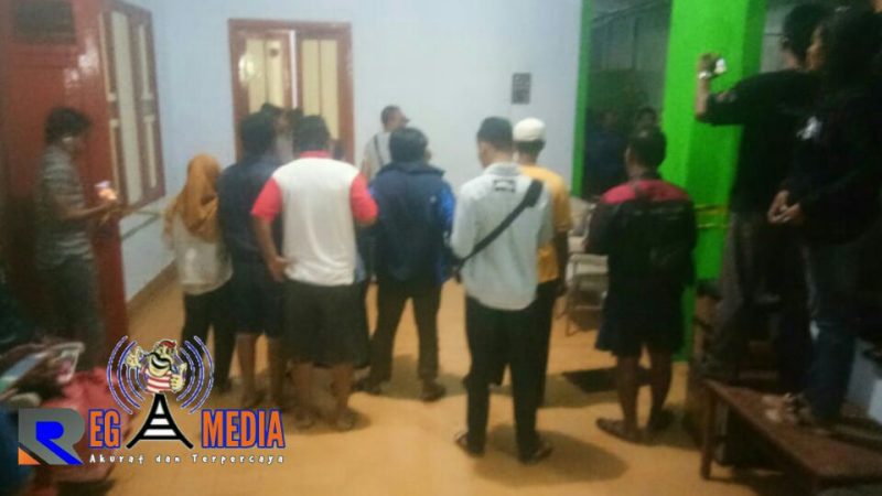 Petugas kepolisian saat mengevakuasi kedua korban.