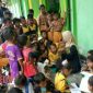 Mahasiswa UTM tengah menemani siswa-siswi SDN Karang Panasan, Blega, membaca di perpustakaan ala KKN kelompok 67 UTM.
