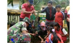 Kekompakan anggota Koramil 06/Margoyoso dengan masyarakat dan siswa-siswi SD setempat saat menanam pohon.