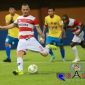 Salah satu pemain Madura United mencoba mengecoh pemain Cilegon United dan mengumpan bola.