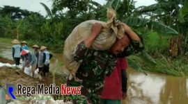 Salah satu personel TNI saat berusaha membawa karung berisi tanah