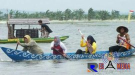 Keseruan warga Desa Pasuruan dalam mengikuti festival lomba perahu rakyat di area persawahan.
