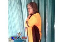 Eliah, tengah berteduh di depan ruko dari derasnya hujan.