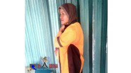 Eliah, tengah berteduh di depan ruko dari derasnya hujan.