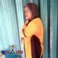 Eliah, tengah berteduh di depan ruko dari derasnya hujan.
