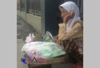 Mak Ati (92 th), beristirahat sambil menunggu pembeli yang ingin membeli dagangannya berupa makanan tradisional.