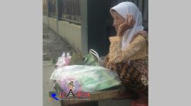 Mak Ati (92 th), beristirahat sambil menunggu pembeli yang ingin membeli dagangannya berupa makanan tradisional.
