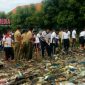 Terlihat personel Polres Bangkalan tengah membersihkan tumpukan sampah yang ada di bibir pantai Pelabuhan Kamal.