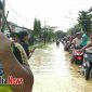 Warga saat melintasi genangan air di arus lalu lintas wilayah Kecamatan Arosbaya, Bangkalan, Madura.