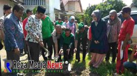 Bupati Bangkalan, R. Abdul Latif Amin Imron terlihat memegang cangkul saat hendak akan menutupi sampah