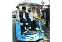 Presiden RI (Joko Widodo) tengah menaiki bentor bersama dengan ibu negara (Iriana).