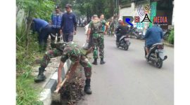 Tampak anggota TNI dan warga tengah bergotong royong membersihkan rerumputan dan sampah.