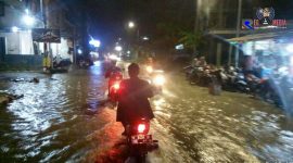Penggendara roda dua saat melintasi genangan air di jalan raya telang menuju UTM