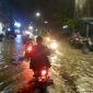 Penggendara roda dua saat melintasi genangan air di jalan raya telang menuju UTM