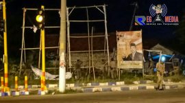 Anggota Satpol PP saat menurunkan APK di Jalan Rajawali, Sampang.