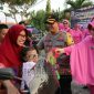 Kapolres Bangkalan AKBP Boby Pa'ludin Tambunan bersama ketua Bhayangkari Bangkalan Ny Andria Boby Tambunan saat memberikan bingkisan takjil kepada masyarakat