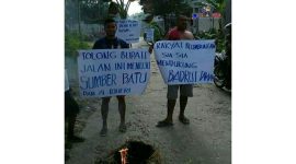 Aksi warga Desa Blumbungan Pamekasan membentangkan poster bertuliskan kalimat kekecewaan atas jalan  yang rusak.