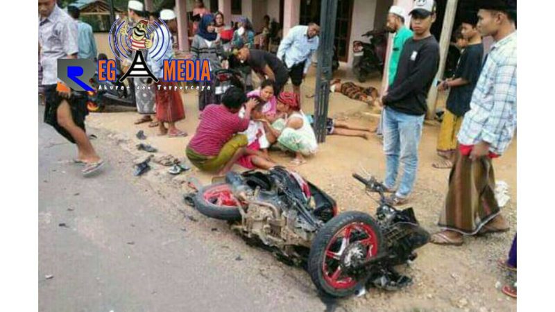 Tampak warga sekitar TKP kecelakaan tengah mengevakuasi korban. Tampak kondisi motor korban ringsek.