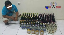 Tersangka AR aliyas Kacong lengkap dengan barang bukti ratusan miras ilegal, diamankan di Mapolres Lumajang.