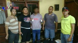Tersangka AH (tengah) menunjukkan barang buktinya saat diamankan petugas kepolisian di Mapolsek Yosowilangun, Lumajang.