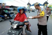 Kapolres Bone Bolango (AKBP Desmont Harjendro) tengah membagikan takjil kepada pengendara yang melintas.