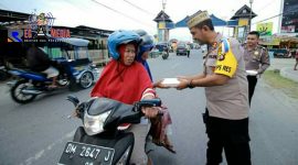 Kapolres Bone Bolango (AKBP Desmont Harjendro) tengah membagikan takjil kepada pengendara yang melintas.