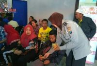 Anggota Polisi Wanita saat membagikan snack kepada masyarakat 