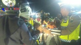 Kasat Lantas Blitar Kota (AKP. Bayu Halim) tengah memberikan bunga dan cokelat kepada pengendara.