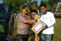 Kapolres Bangkalan AKBP Boby Pa'ludin Tambunan saat memberikan simbolis penghargaan kepada Penggiat keamanan Wilayah UTM Taufik Hidayah.