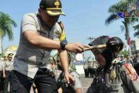 Kapolres Bandung (AKBP Indra Hermawan, SH.SIK.MH) menyiramkan bunga kepada anggotanya sebagai sesi kenaikan pangkat.