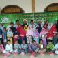 Pengurus Yayasan Fastabiqul Khoirot Alhikmah pose bersama dengan anak yatim yang mendapatkan santunan.