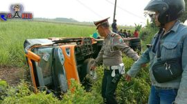 Kondisi bus pariwasata yang terguling, terlihat pihak kepolisian dan warga usai mengevakuasi korban.