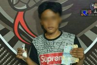 Pelaku pengedar pil koplo menunjukkan barang buktinya, saat diamankan di markas Tim Cobra.