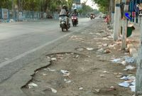 Tampak sampah berserakan di pinggir dua sisi jalan.