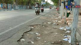 Tampak sampah berserakan di pinggir dua sisi jalan.