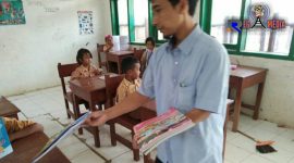 Salah satu guru SDN Bapelle 1 saat membagikan buku pelajaran sebelum dimulainya kegaiatan belajar mengajar.
