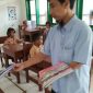 Salah satu guru SDN Bapelle 1 saat membagikan buku pelajaran sebelum dimulainya kegaiatan belajar mengajar.