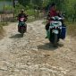 Terlihat beberapa pengendara melintasi jalan poros Desa Torjunan yang rusak.
