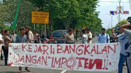 Sejumlah massa terlihat membentangkan spanduk yang bertuliskan 