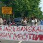 Sejumlah massa terlihat membentangkan spanduk yang bertuliskan 